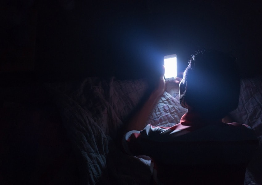 Woman using mobile phone in bed