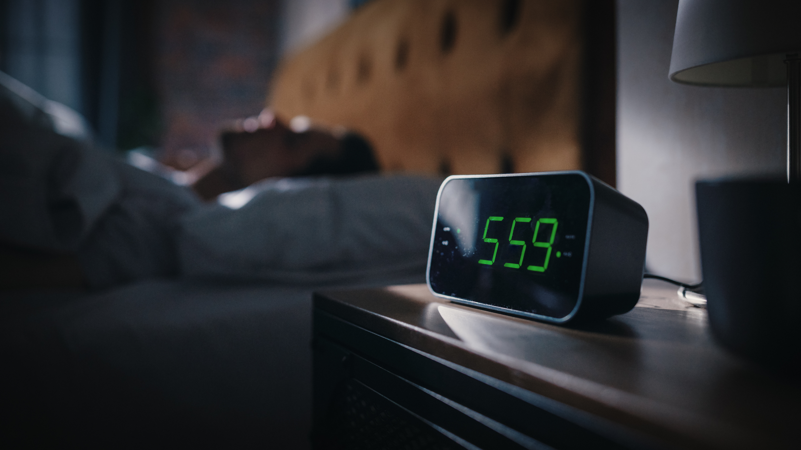 Handsome Man Wakes Up and Turns off Alarm Clock. Proceeds to Have a Productive Day of Work. Stylish Apartment. Focus on the Clock Showing Five Hours and Fifty Nine Minutes in the Morning